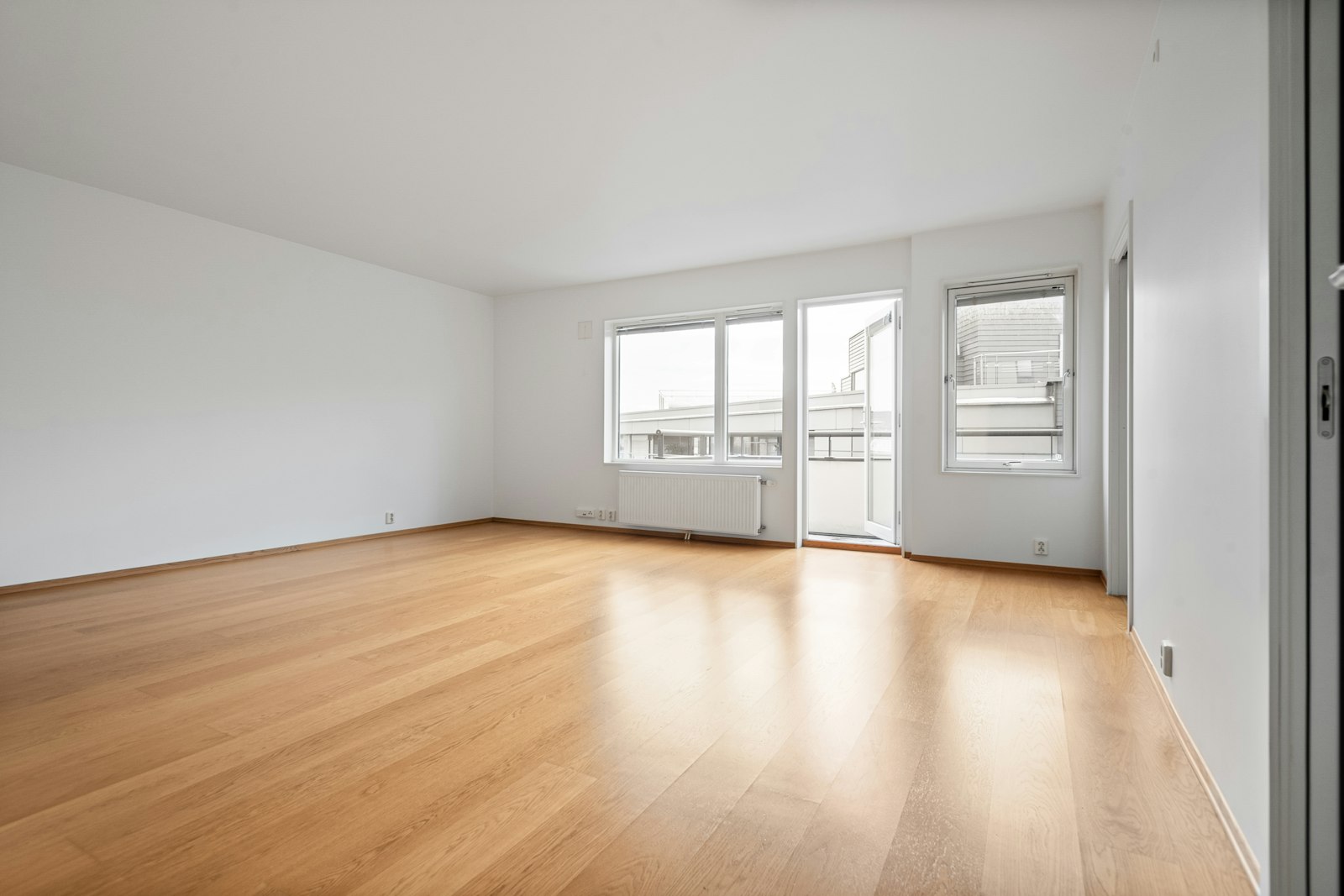 Empty rental unit with white walls and new wood flooring