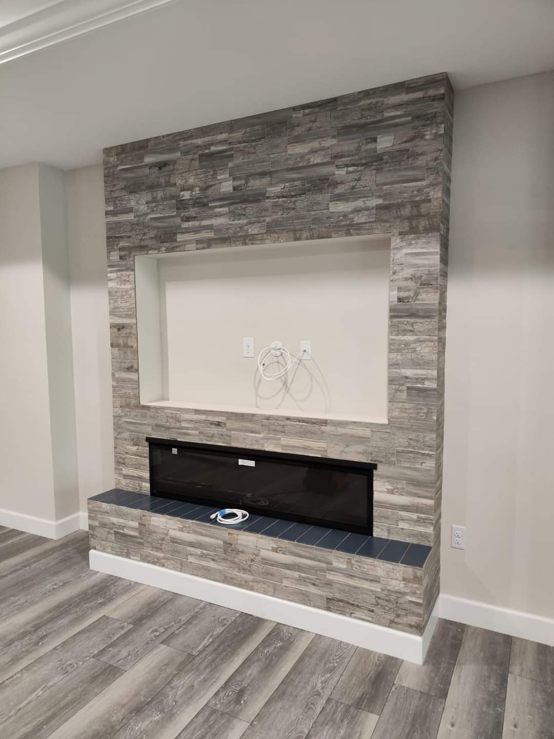 Stone accent wall with built-in electric fireplace and media niche